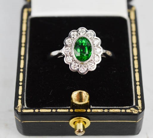 An 18ct white gold and Tsavorite garnet and diamond ring, of flowerhead form, with approx 1ct