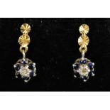 A pair of 18ct gold earrings set with blue stones, flower head form.