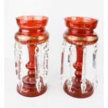 A pair of Victorian lustres, red glass decorated with gilding, and clear glass drops, 30cm high.