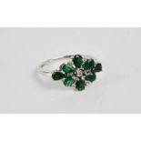 A 9ct white gold and emerald flower head form ring, 2.7g. Size S