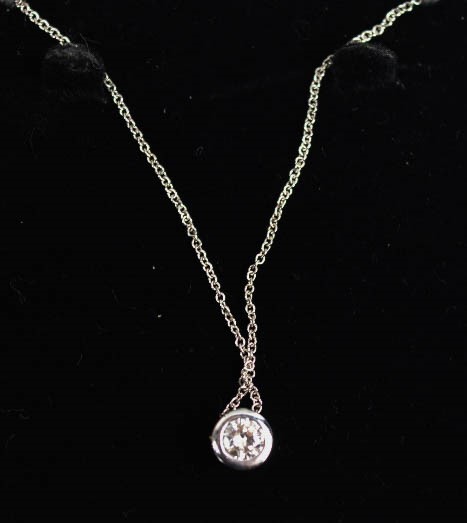 An 18ct white gold and diamond pendant necklace, the ½ct diamond on a 'floating'/slider pendant.