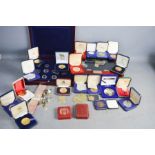 A quantity of cased commemorative coins, Brilliant uncirculated examples, together with cufflinks.