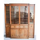 A Regency mahogany Norfolk breakfront bureau bookcase, the upper section having glazed doors