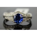 A 14ct white gold, blue sapphire and diamond ring, oval sapphire approximately 1ct, size M, 2.5g.