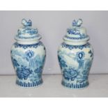 A pair of Chinese blue and white 20th century jars with dog of fo finialled covers, 67cm high.