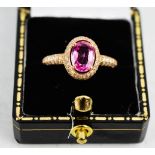 An 18ct rose gold and pink sapphire ring, bordered with diamonds, approximately 1.5cts, size N/O,