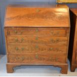 A Georgian mahogany bureau, the fall front enclosing a fitted interior, raised above graduated