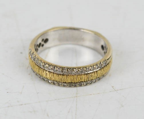 A 9ct white and yellow gold band ring set with thirty four diamonds, (unmarked), 5.6g.