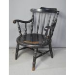 A spindle back armchair, painted black.