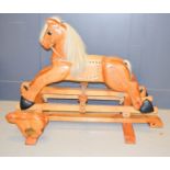 A wooden rocking horse, with carved rabbit to the stand.