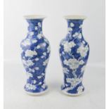 An early 20th century pair of blue and white baluster vases, depicting prunus blossom, with four