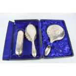 A sterling silver brush and mirror set in a case.