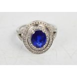 An 18ct white gold and sapphire ring, approximately 1.5ct, with diamond set border and shoulders,