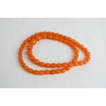 A clear amber necklace, composed of graduated beads, 70 cm long, 49g.