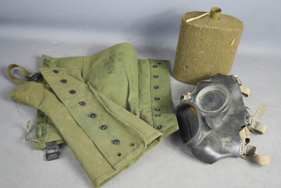 A WWII 1945 army gaiter, home office gas mask and water canteen.
