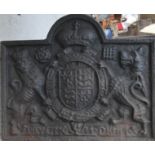 A cast iron fire back with a coat of arms.