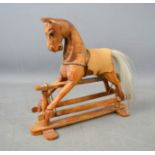 A miniature wooden carved rocking horse.