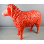 A life size model sheep, painted red.