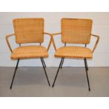 Two mid-century wicker chairs, with black painted frame.