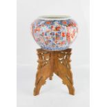 A 19th century Chinese Imari bowl with carved wooden stand.