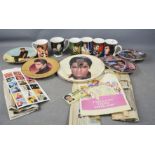 A group of Elvis memorabilia including Zippo, collectors plates, mugs, printed ephemera and stamps.