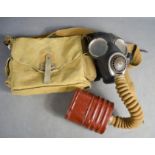 A WWII 1940 gas mask, filter and bag.