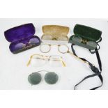 A group of spectacles, some in cases, and on ribbon.