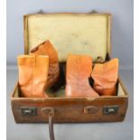 A vintage leather suitcase together with a pair of Tape Master leather boots.