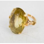 A yellow metal dress ring, set with oval cut topaz, size N, 10.4g.