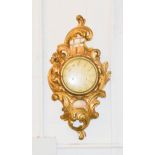 A French style giltwood wall clock, with convex glass case bordered by carved and gilded scrollwork.