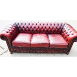 A red leather Chesterfield type three seater settee.
