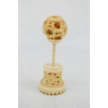 A Mid 19th century Chinese hand carved puzzle ball of dragon design, on a carved stand.