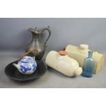 Two stoneware glazed footwarmers, glass bottles, pewter teapot, shaving set, and blue and white