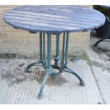 Three cast iron garden table bases, painted green, with hoof feet, and later wooden tops.