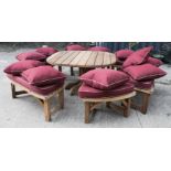 A garden set of bench/stools and centre table, with red cushions.