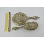 An Art Nouveau white metal three piece dressing table set.