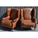 A pair of leather wingback armchairs