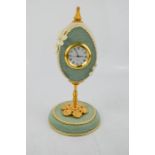 An ornamental clock, in the form of an egg, raised on a gilt metal stand, 17½cm high.