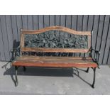A green painted cast iron garden bench, with wooden slats, and the back depicting flowers.