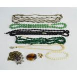A group of vintage necklaces to include green jadeite beads, filigree flower pendant.