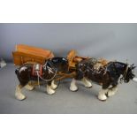 Two vintage pottery Shire Horses with wooden carts.