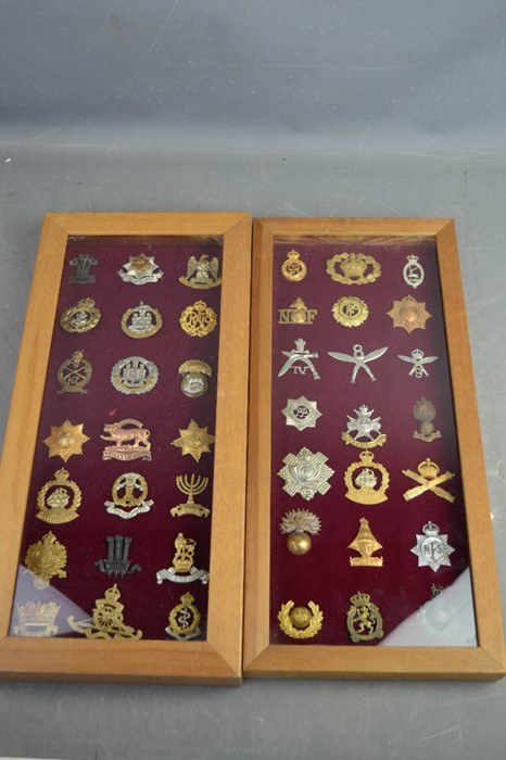 Two framed sets of cap badges.