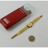 An Emka ladies wristwatch, with gold coloured dial and strap, together with a 1945 Liberty Quarter