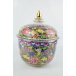 A Chinese bowl and cover, decorated with peonies, and the lid having a gold painted finial, 27cm