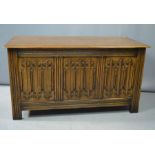 An oak blanket chest, with carved three panel front, raised on style feet, 59 by 108 by 48cm.