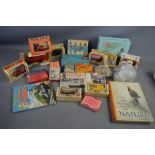 A group of boxed Lledo and Corgi cars, vintage card games, and a microscope set.
