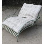 A two seater cast painted metal garden seat with cushion.