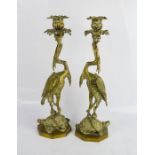 A pair of early 20th century brass candlesticks cast with cranes, serpents and tortoise.