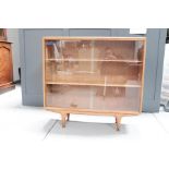 A mid-century glass fronted bookcase.