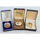 Three ceramic brooches, hand painted and signed P Platt, two in 9ct gold settings, the other in